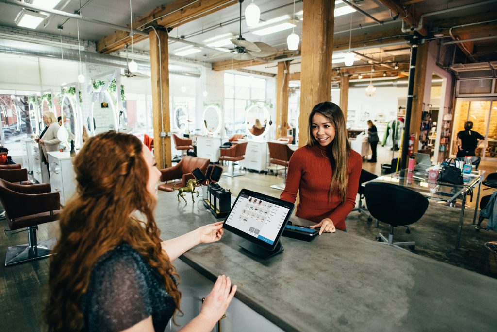 Relation client et digital Hotesse qui salue sa cliente au comptoire d'un coworking